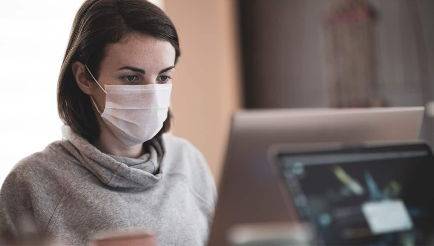 Woman at desk wearing mask