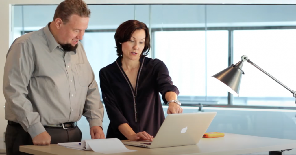 CEO, Lauren Rivers reviewing laptop with Technology Director